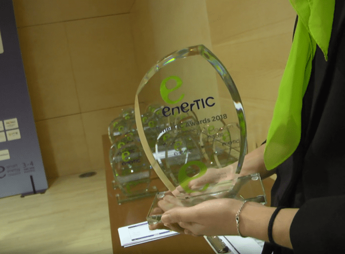 woman holding enerTIC award glass trophy at gala