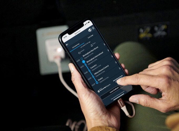 Hands holding a smartphone. Real-time information regarding the journey is displayed on the phone screen.