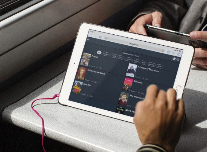 Passengers sat on a train are able to access onboard entertainment content such as popular TV shows while they travel