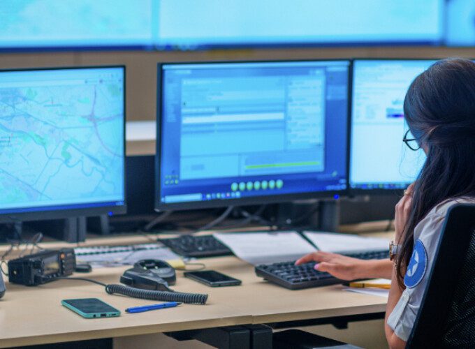 A security officer sits in front of screens monitoring transport activity
