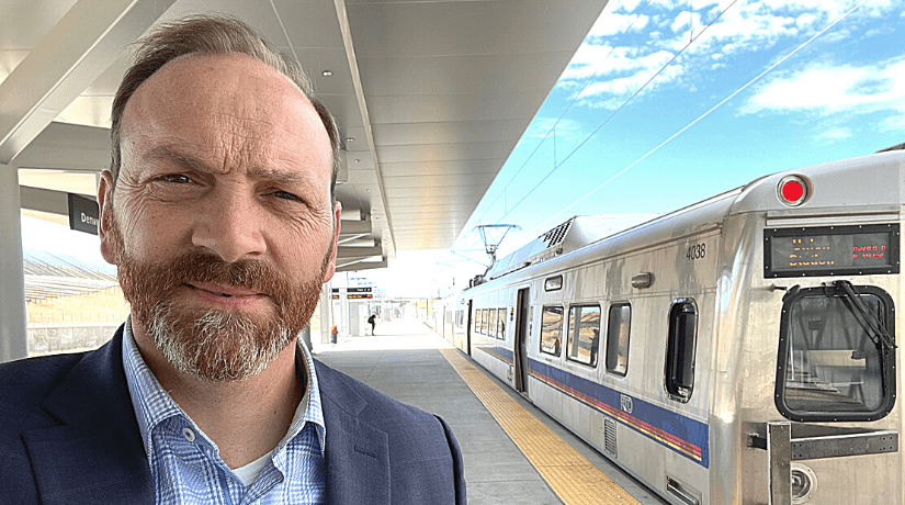 Author John Walton stands next to a train in Denver, Colorado