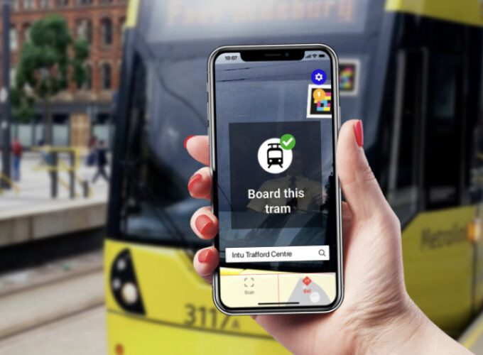 Phone displaying navigation instructions in front of tram