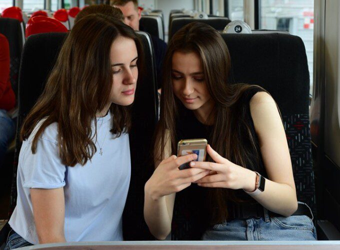 Two passengers looking at the onboard portal to get real-time journey information