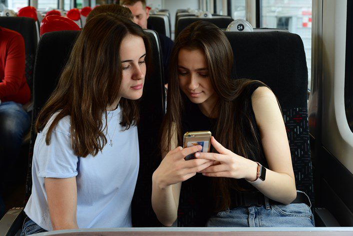 Two passengers looking at the onboard portal to get real-time journey information