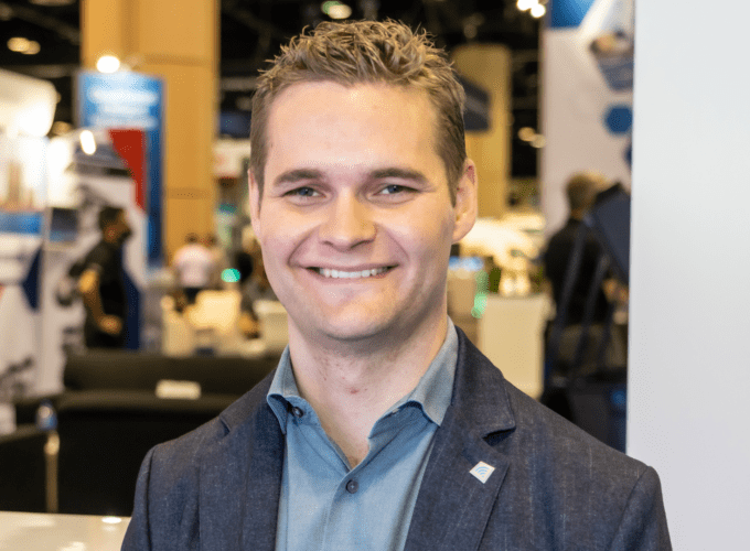 Portrait photo of Martin Anderberg, Icomera Innovation Solutions Engineer, taken at APTA EXPO. Martin wears a blue shirt and is smiling