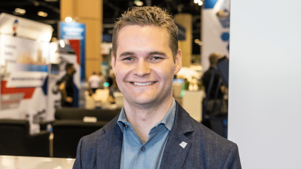 Portrait photo of Martin Anderberg, Icomera Innovation Solutions Engineer, taken at APTA EXPO. Martin wears a blue shirt and is smiling