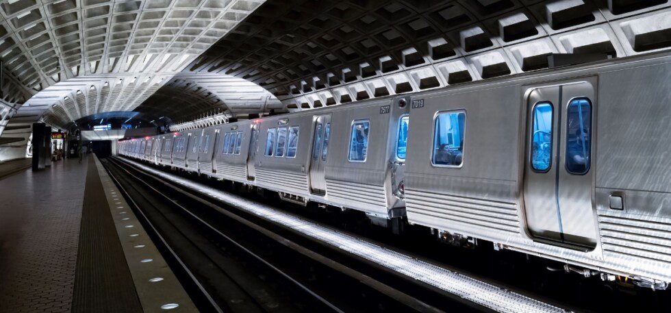 Silver train waits on a platform
