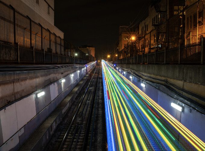 The lights of a train can be seen stretching along the tracks at night