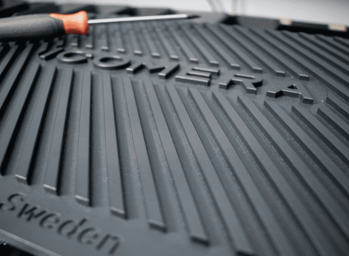 A close up of Icomera's X7 router chassis which is dark grey, with grooved heat-sinks and imprinted with 