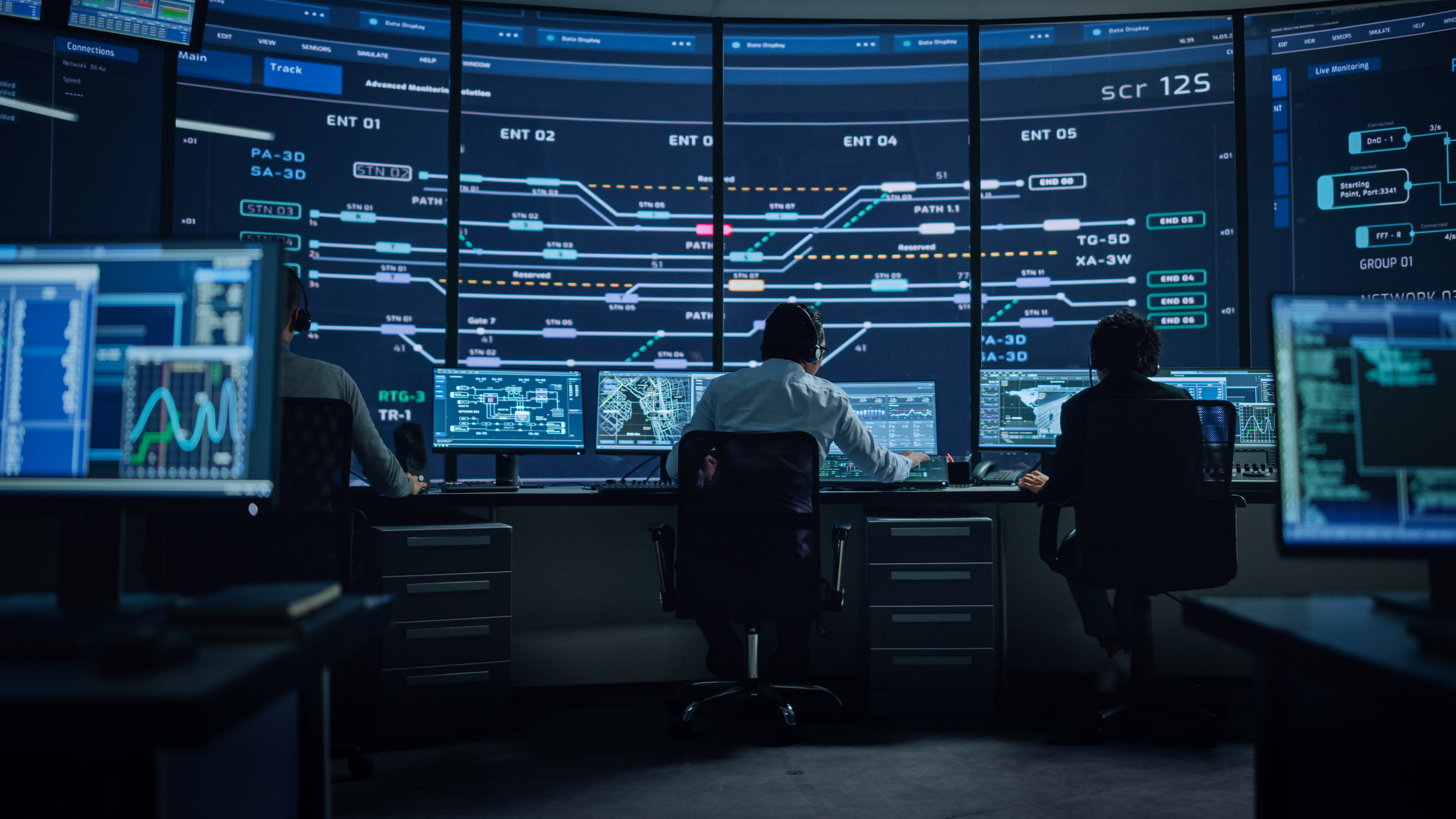 Professional IT Technical Support Specialists and Software Programmer Working on Computers in Monitoring Control Room with Digital Screens with Server Data, Blockchain Network and Surveillance Maps.